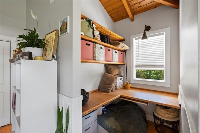 home office with built in study area, wooden ceiling, and lofted ceiling with beams