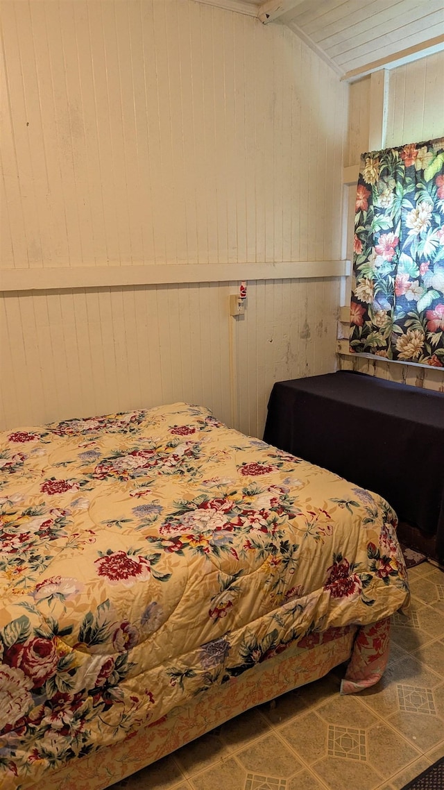 bedroom featuring wood walls