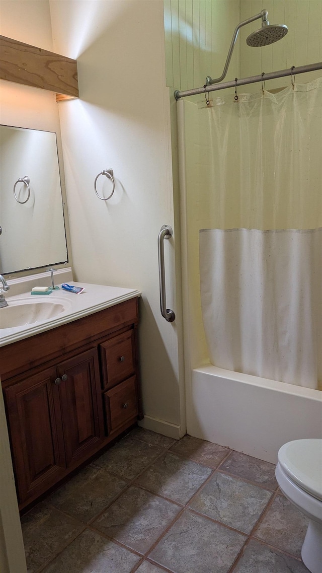 full bathroom featuring shower / bath combo, vanity, stone tile floors, and toilet