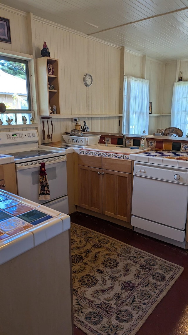 kitchen featuring open shelves, tile countertops, wood walls, and white appliances
