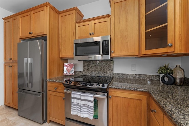 kitchen with stainless steel appliances and dark stone counters