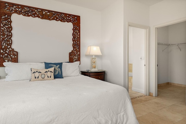 bedroom featuring a walk in closet, tile patterned flooring, and a closet