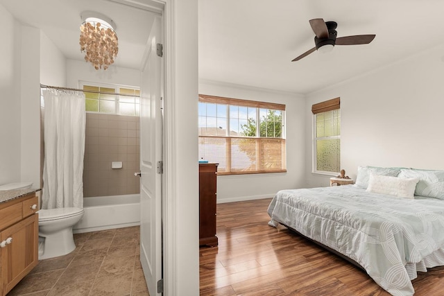 bedroom with connected bathroom and light hardwood / wood-style floors