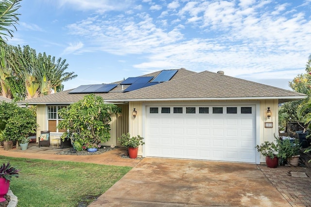 single story home with a garage and solar panels