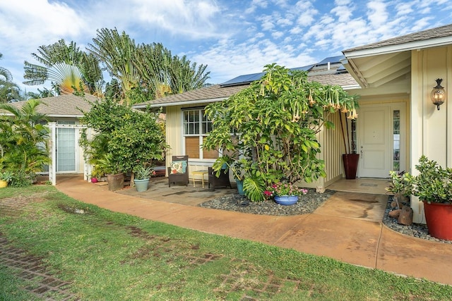 property entrance with a patio area and solar panels