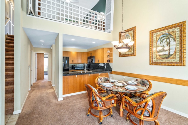 carpeted dining space featuring sink and a high ceiling