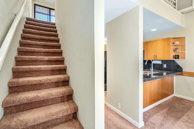 stairway with carpet floors and sink