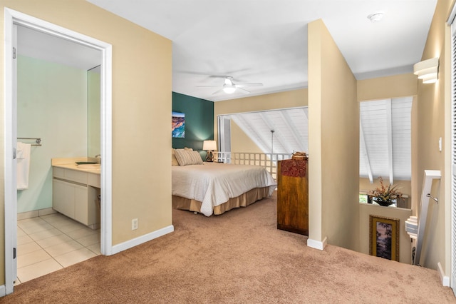 bedroom featuring ceiling fan, light carpet, and connected bathroom