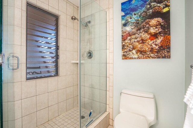 bathroom featuring toilet and a shower with shower door