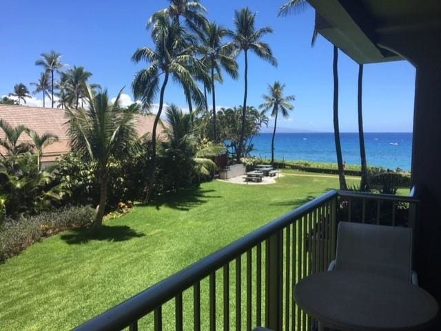 balcony featuring a water view and an outdoor fire pit