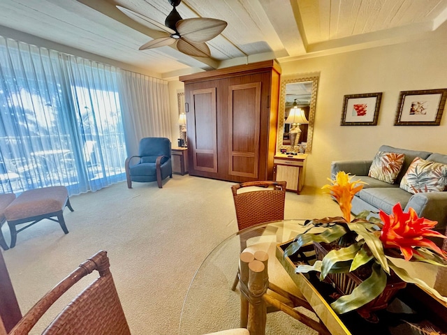 carpeted living room featuring ceiling fan and beam ceiling