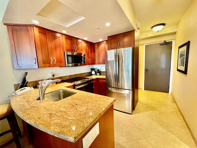 kitchen with stainless steel appliances, light tile patterned flooring, sink, kitchen peninsula, and light stone counters