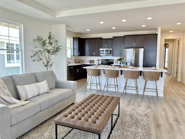 living area with light wood-type flooring and recessed lighting