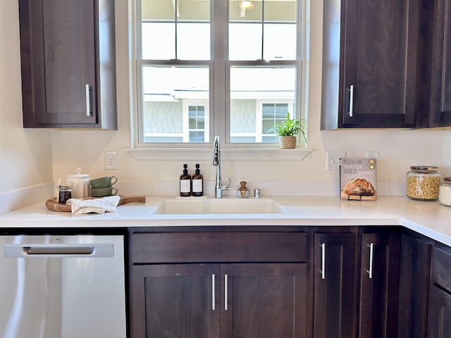 kitchen featuring a sink, dark brown cabinets, stainless steel dishwasher, and light countertops