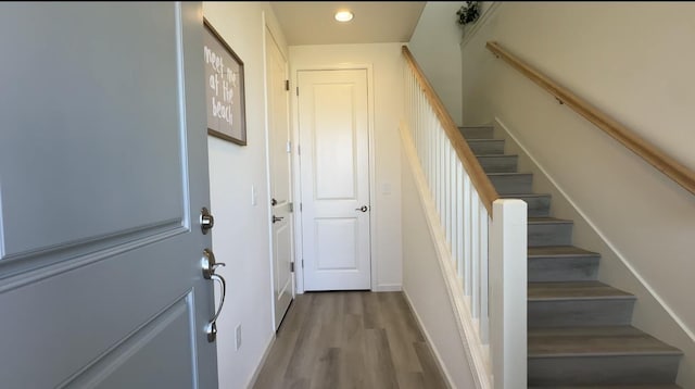 doorway with stairs, baseboards, wood finished floors, and recessed lighting