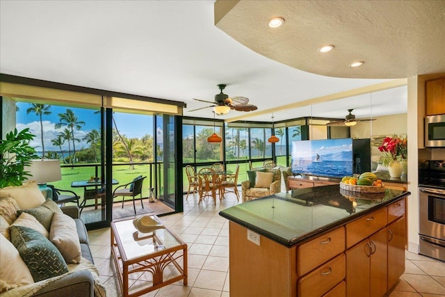 2936 S Kihei Rd Unit 213, Kihei, HI 96753 - kitchen with a ceiling fan, stainless steel appliances, light tile patterned floors, floor to ceiling windows, and brown cabinetry