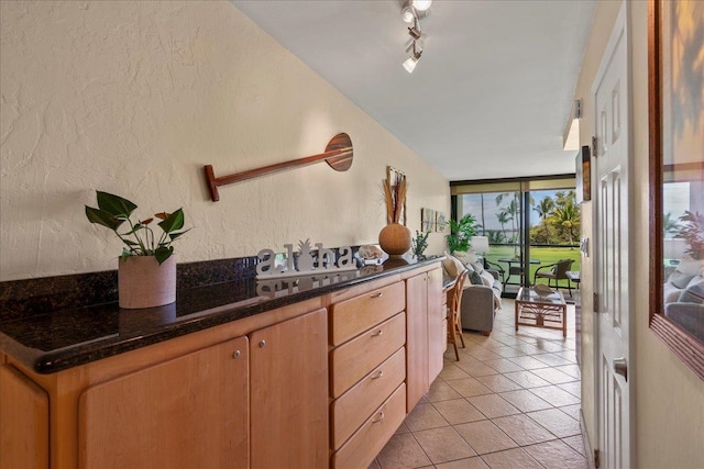 2936 S Kihei Rd Unit 213, Kihei, HI 96753 - kitchen featuring expansive windows, light tile patterned flooring, a textured wall, and rail lighting