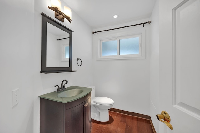 bathroom with wood-type flooring, vanity, and toilet