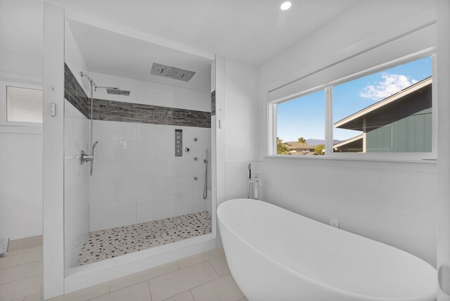 bathroom featuring tile patterned floors and independent shower and bath