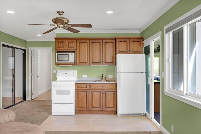 kitchen featuring white appliances, ceiling fan, ornamental molding, and sink