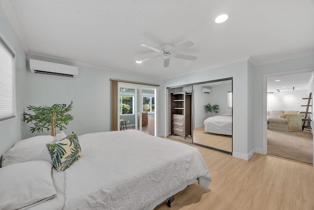 bedroom with ceiling fan, an AC wall unit, light hardwood / wood-style floors, a closet, and ornamental molding