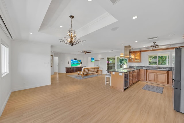 kitchen featuring pendant lighting, crown molding, light wood-type flooring, a breakfast bar area, and stainless steel appliances