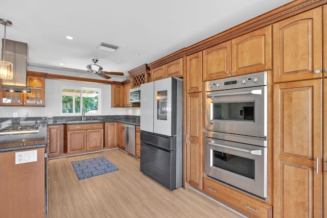 kitchen with ceiling fan, sink, stainless steel appliances, light hardwood / wood-style flooring, and decorative light fixtures