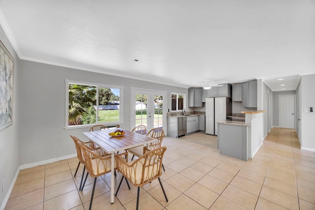 dining room featuring crown molding, french doors, light tile patterned flooring, and sink