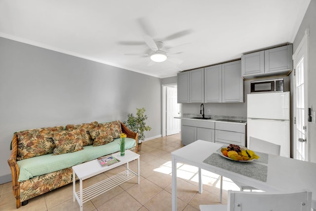 kitchen featuring gray cabinetry, white refrigerator, sink, ceiling fan, and light tile patterned floors