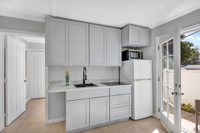 kitchen featuring gray cabinetry, sink, light tile patterned floors, and white fridge