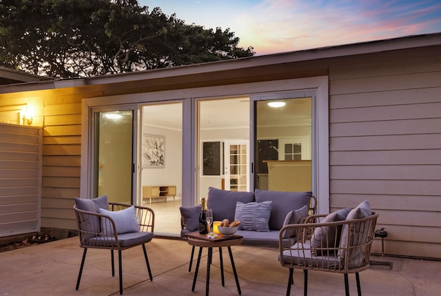 patio terrace at dusk featuring an outdoor hangout area