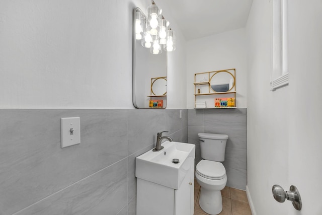 bathroom with tile patterned floors, vanity, tile walls, and toilet