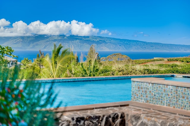 view of swimming pool featuring a water and mountain view