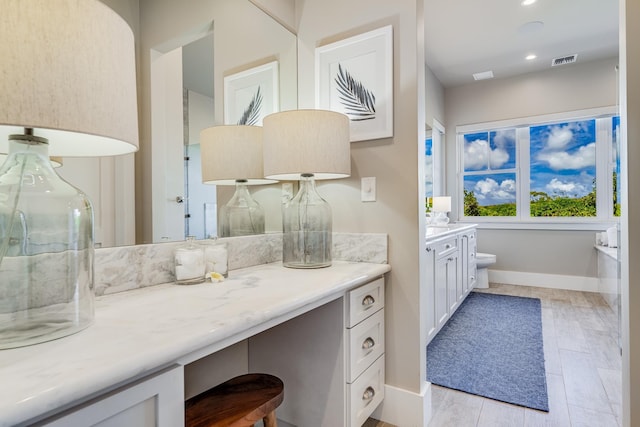 bathroom with hardwood / wood-style floors, vanity, and toilet