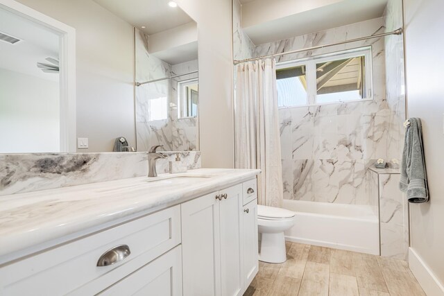 full bathroom with shower / bath combo with shower curtain, vanity, wood-type flooring, and toilet