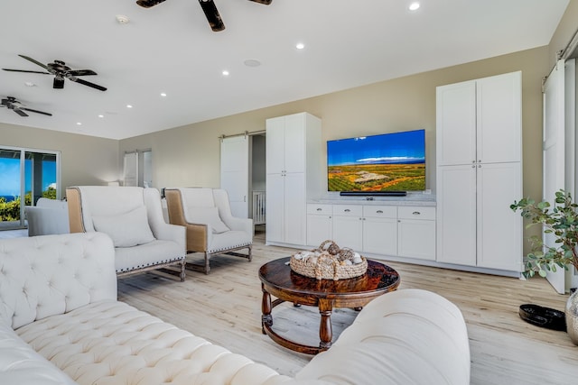 living room featuring a barn door and light hardwood / wood-style flooring