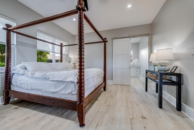 bedroom featuring light hardwood / wood-style floors and a barn door