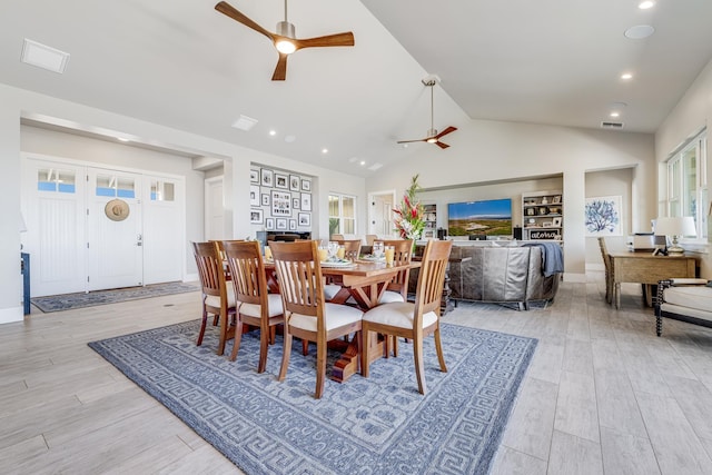 dining space featuring ceiling fan, light hardwood / wood-style flooring, and high vaulted ceiling