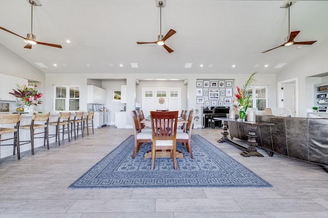 dining area with light hardwood / wood-style floors, high vaulted ceiling, and plenty of natural light