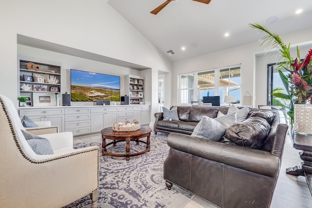 living room featuring built in features, high vaulted ceiling, light hardwood / wood-style flooring, and ceiling fan