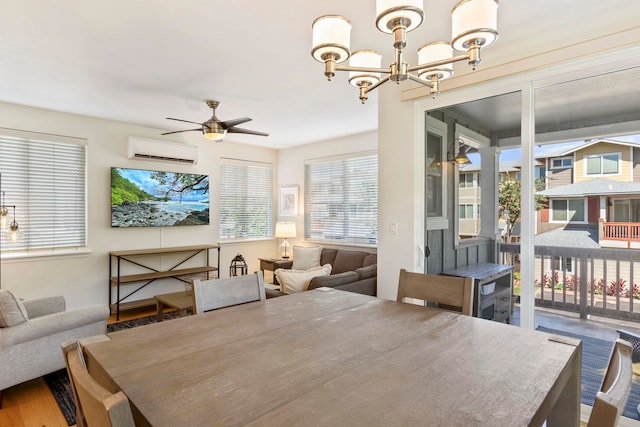 dining space featuring ceiling fan with notable chandelier, wood finished floors, and a wall mounted AC