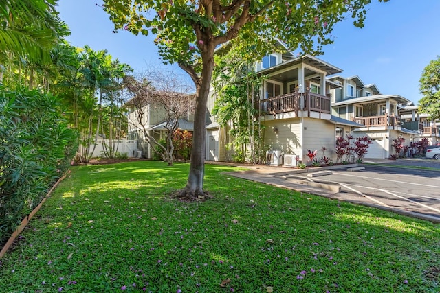 view of front of property with a balcony, fence, and a front lawn