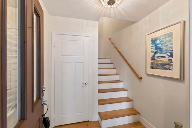 stairway with wood finished floors and baseboards