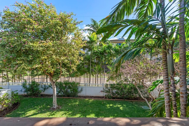 view of property exterior with fence and a lawn