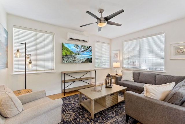 living area with ceiling fan, baseboards, wood finished floors, and a wall mounted AC