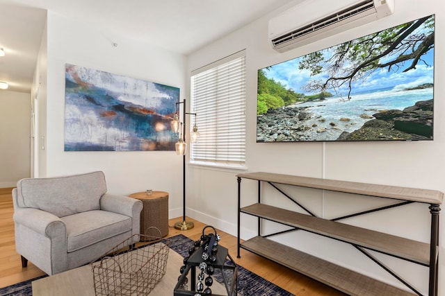 living area featuring a wall mounted AC, wood finished floors, and baseboards