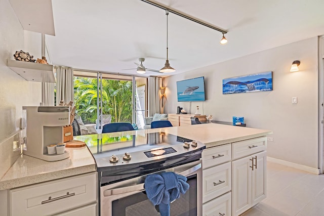 kitchen featuring light stone counters, decorative light fixtures, white cabinets, ceiling fan, and stainless steel electric range