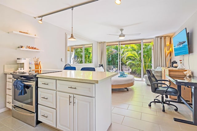 kitchen with pendant lighting, light countertops, electric range, expansive windows, and white cabinetry