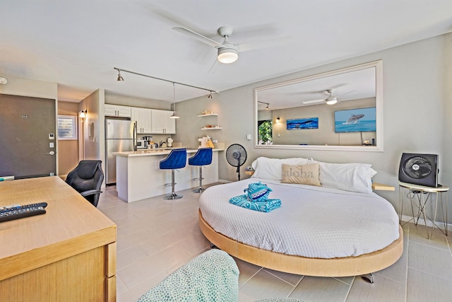 bedroom with freestanding refrigerator, rail lighting, and ceiling fan