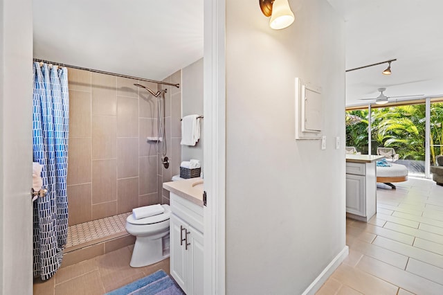 full bath featuring toilet, a tile shower, vanity, and a ceiling fan